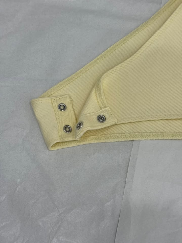 Dettaglio della chiusura a pressione del Body Pearl giallo